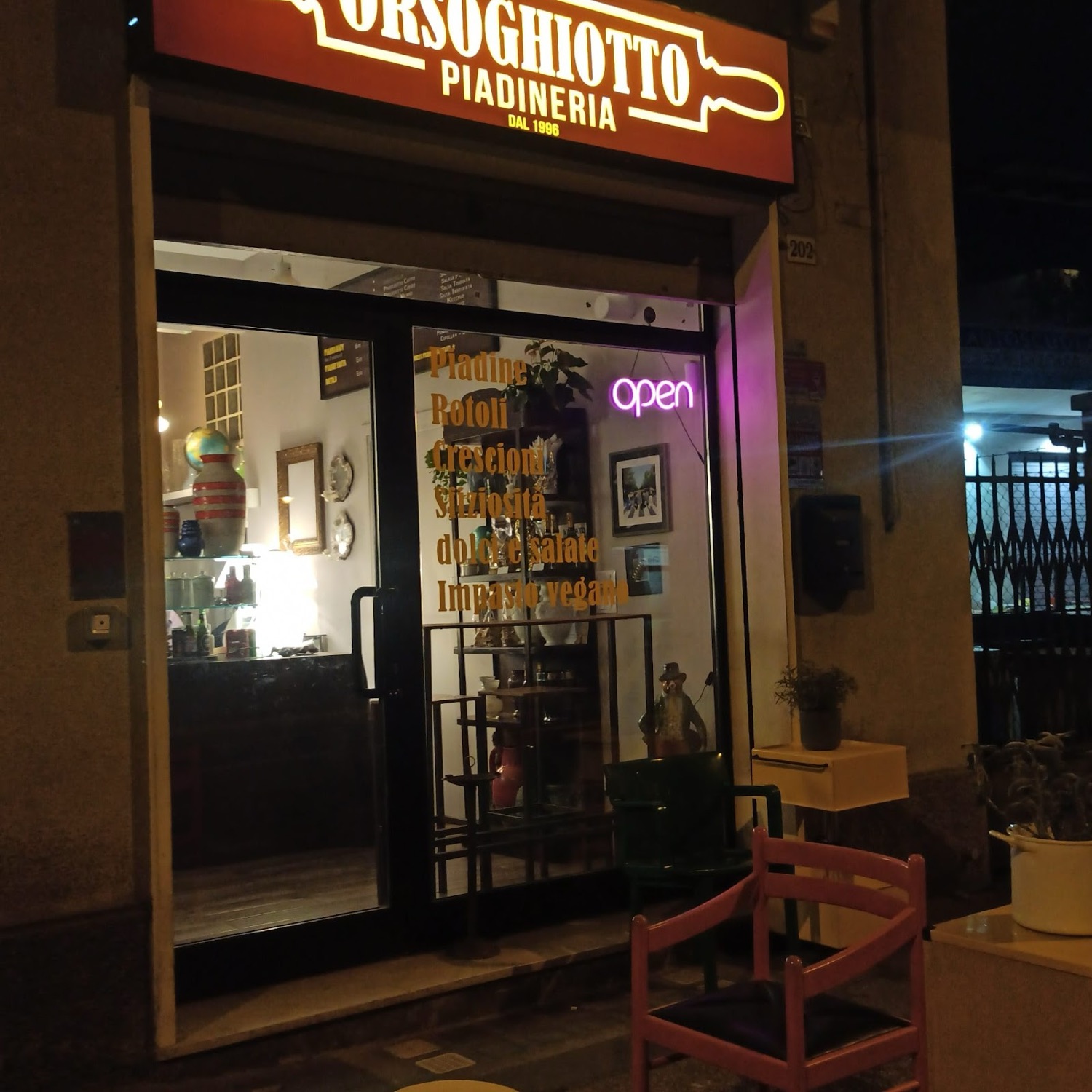 L'insegna Orsoghiotto illuminata sulla Via Emilia la sera
